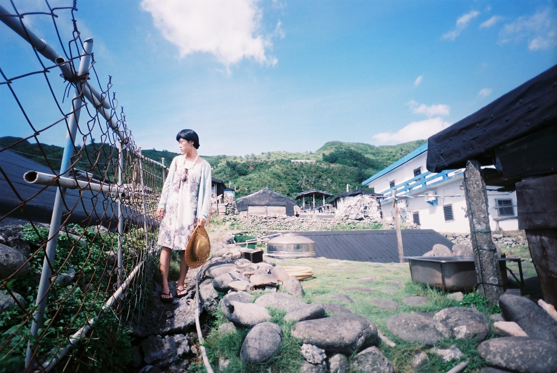 a woman walking on a foot bridge over some rocks