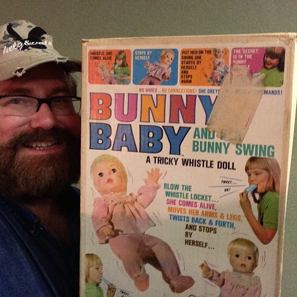 a man holding up an ad for a bunny baby doll