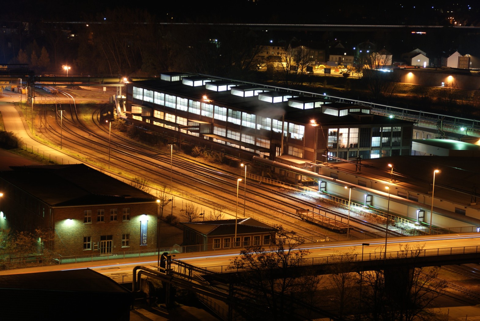 train yard at night with lights on all the buildings