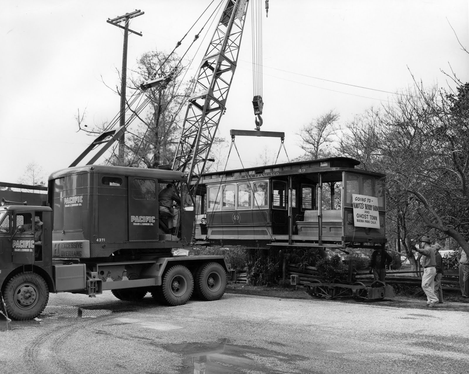 a large crane next to a house on a street