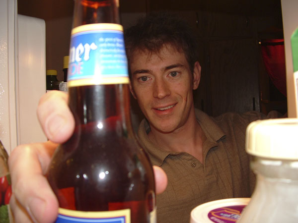 a close up of a person holding a bottle of beer