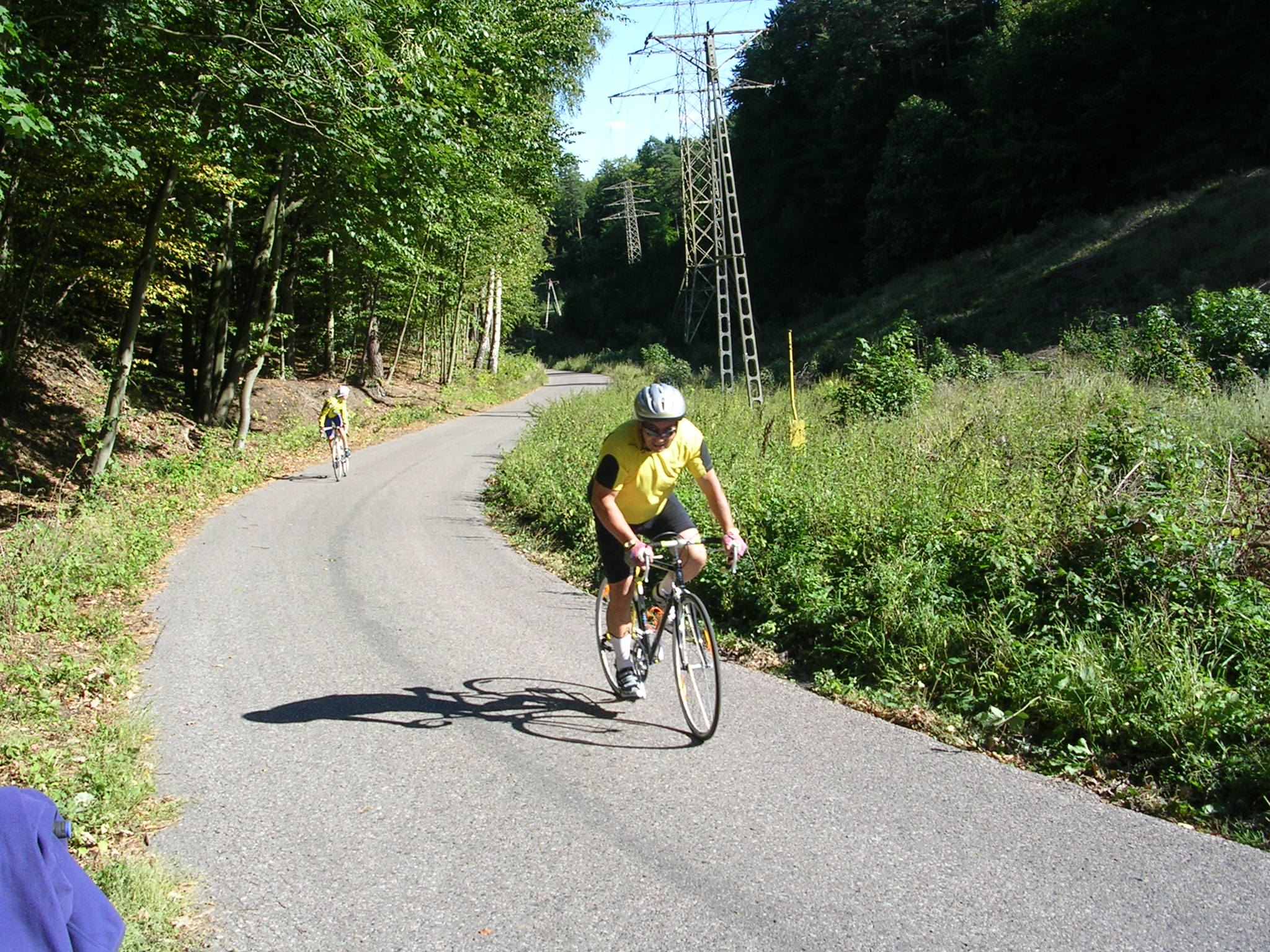 two people on bicycles riding down a road