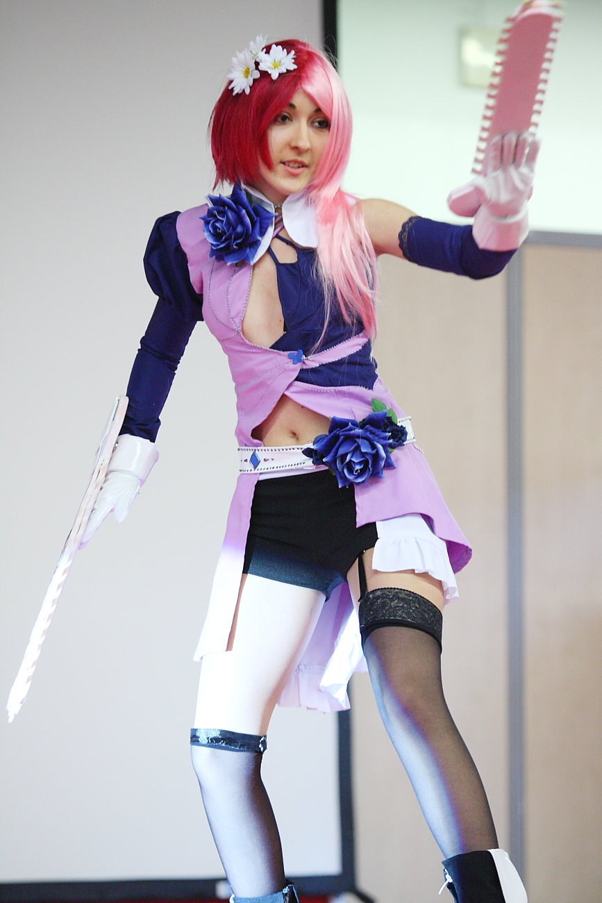 a girl with pink hair and black boots standing on stage