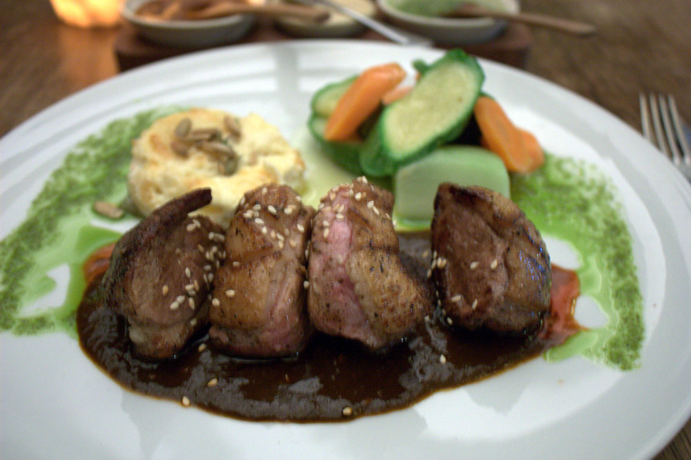 a plate topped with meat, vegetables and sauce