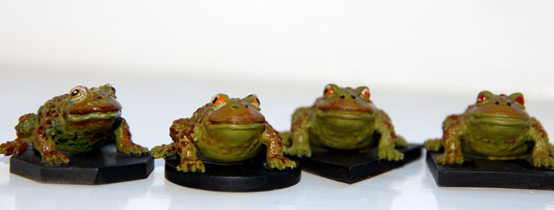 a group of three frogs sitting next to each other
