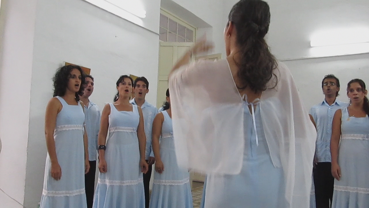 a group of people are singing in front of a mirror