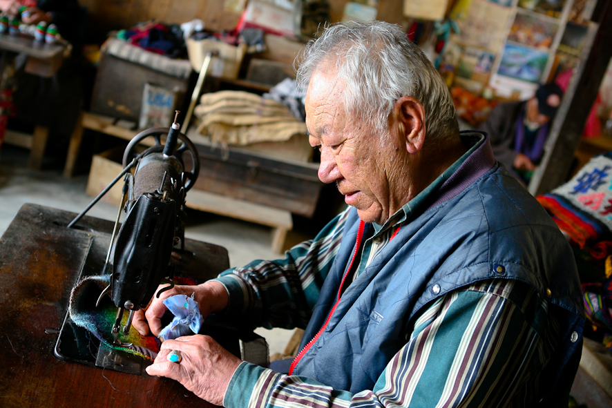 the old man is sewing soing on the table