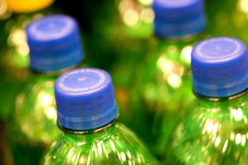 close up s of green plastic bottles stacked on top of each other