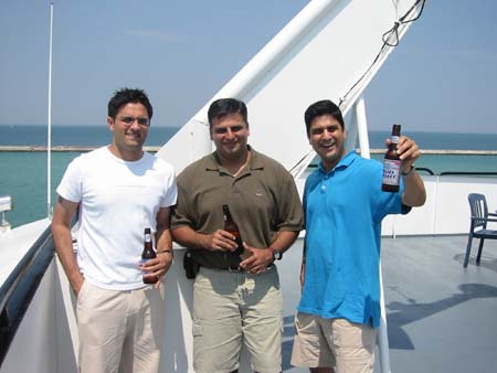 three men pose for a po on the deck of a boat