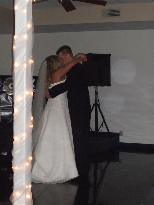 a couple dance at a wedding reception in the corner