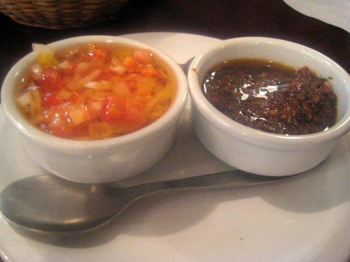 a small bowl of soup on top of a white plate with a spoon