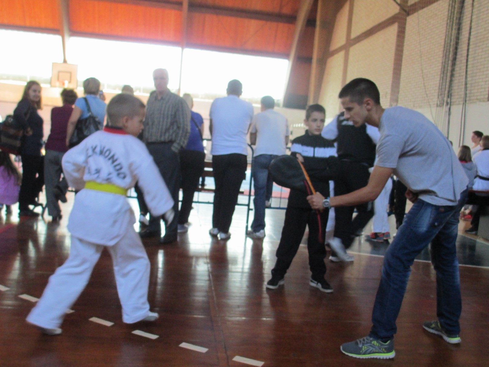 a man with a little boy wearing a suit hitting a baseball