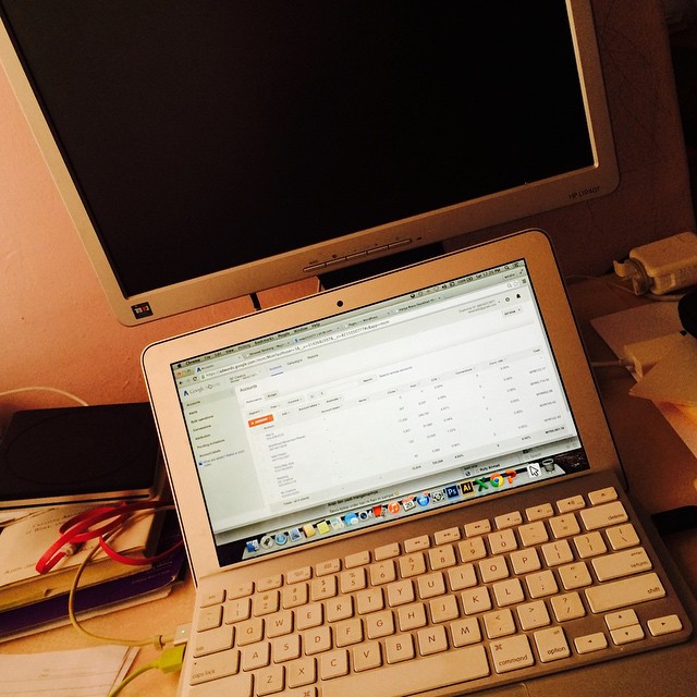 a computer monitor, laptop keyboard, notebook and mouse on a desk