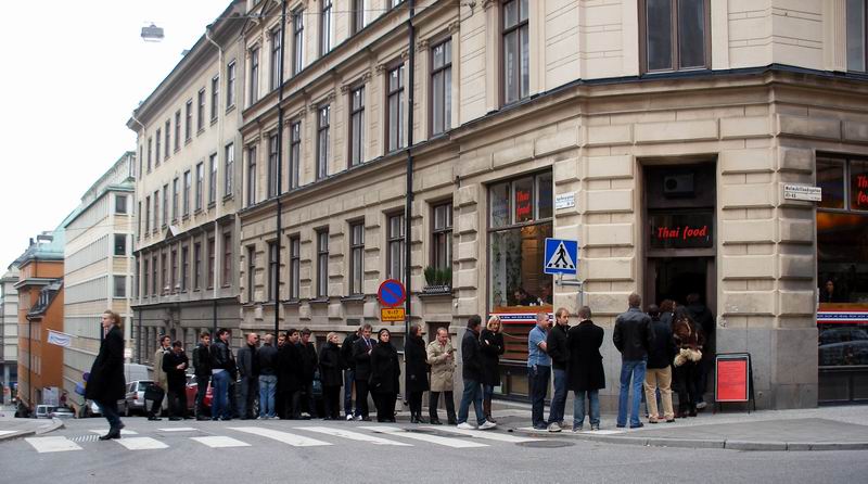 people lined up outside of an art gallery