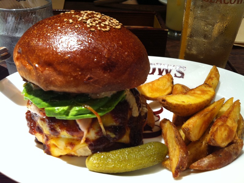 a burger and a pickle are sitting on a plate