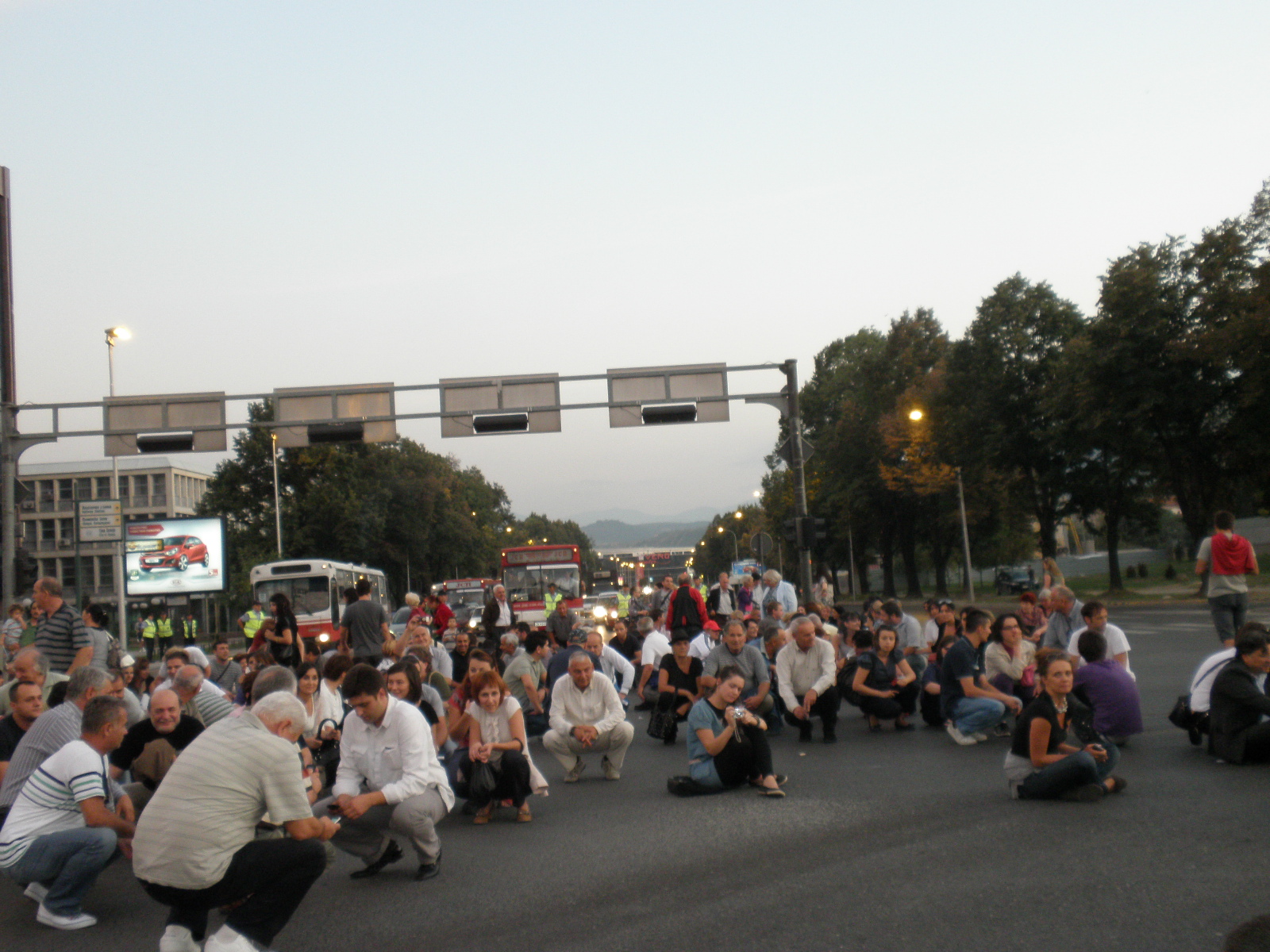 a crowd of people sitting around and standing in the street