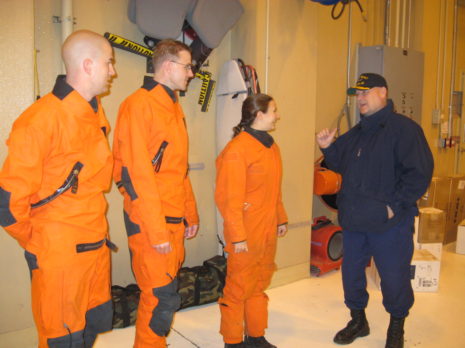 an instructor shows two young sailors how to do a drill