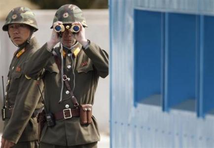 soldiers wearing helmets saluting with binoculars while standing near blue metal structure