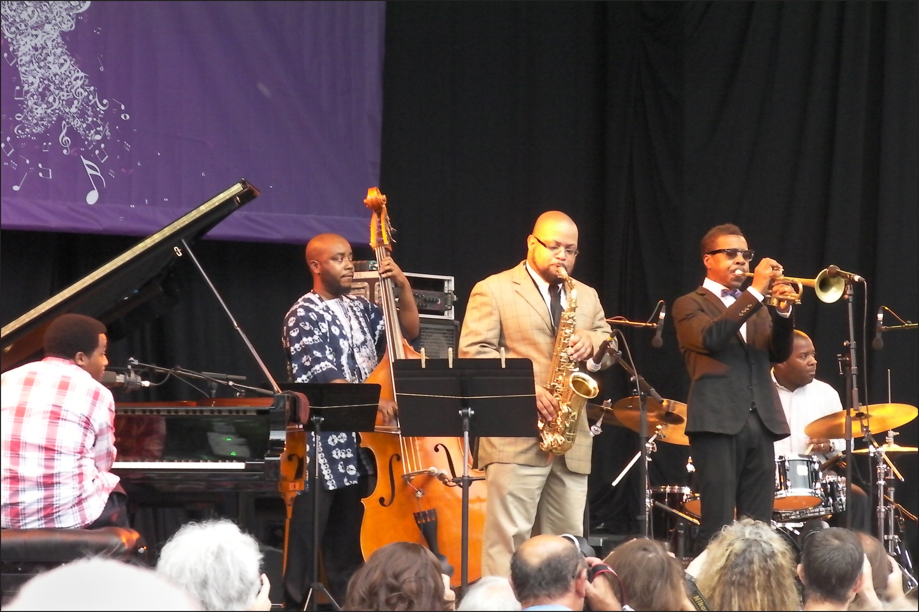 two men are performing on stage and a large audience is watching