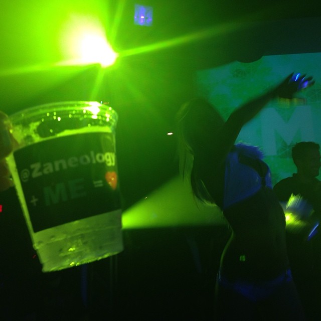 a person is dancing in a nightclub with two green lights
