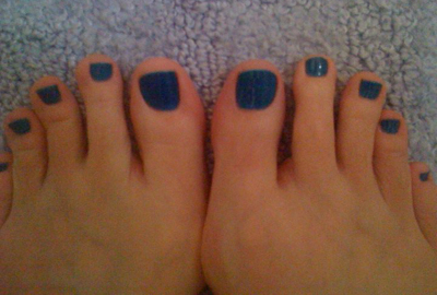 a woman with dark blue nails and black toes
