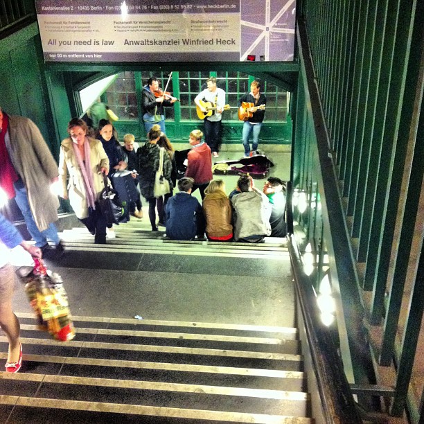 group of people standing at the bottom of a stairwell while waiting to board