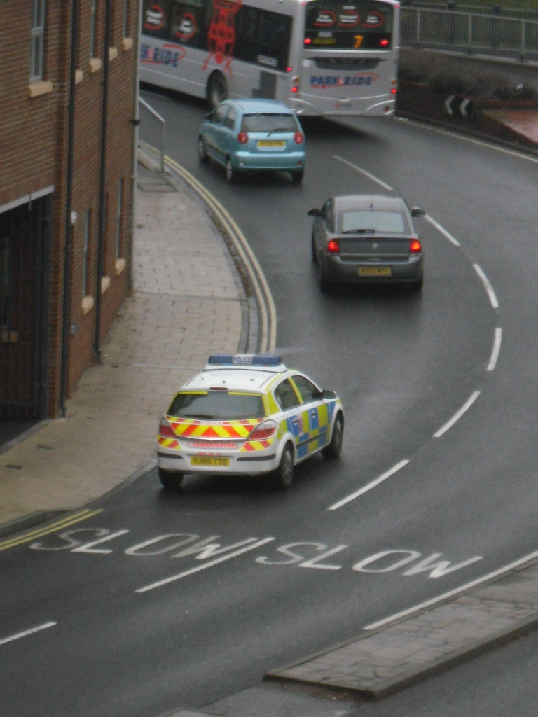 two cars driving down the road next to each other