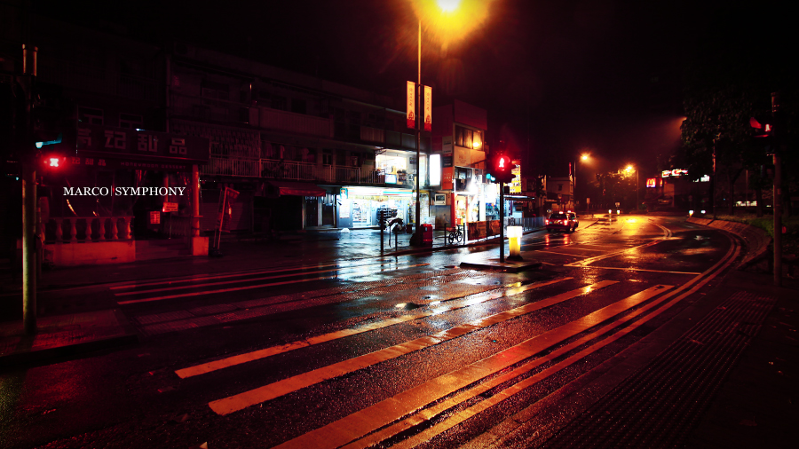 wet night time street scene with traffic light and lights