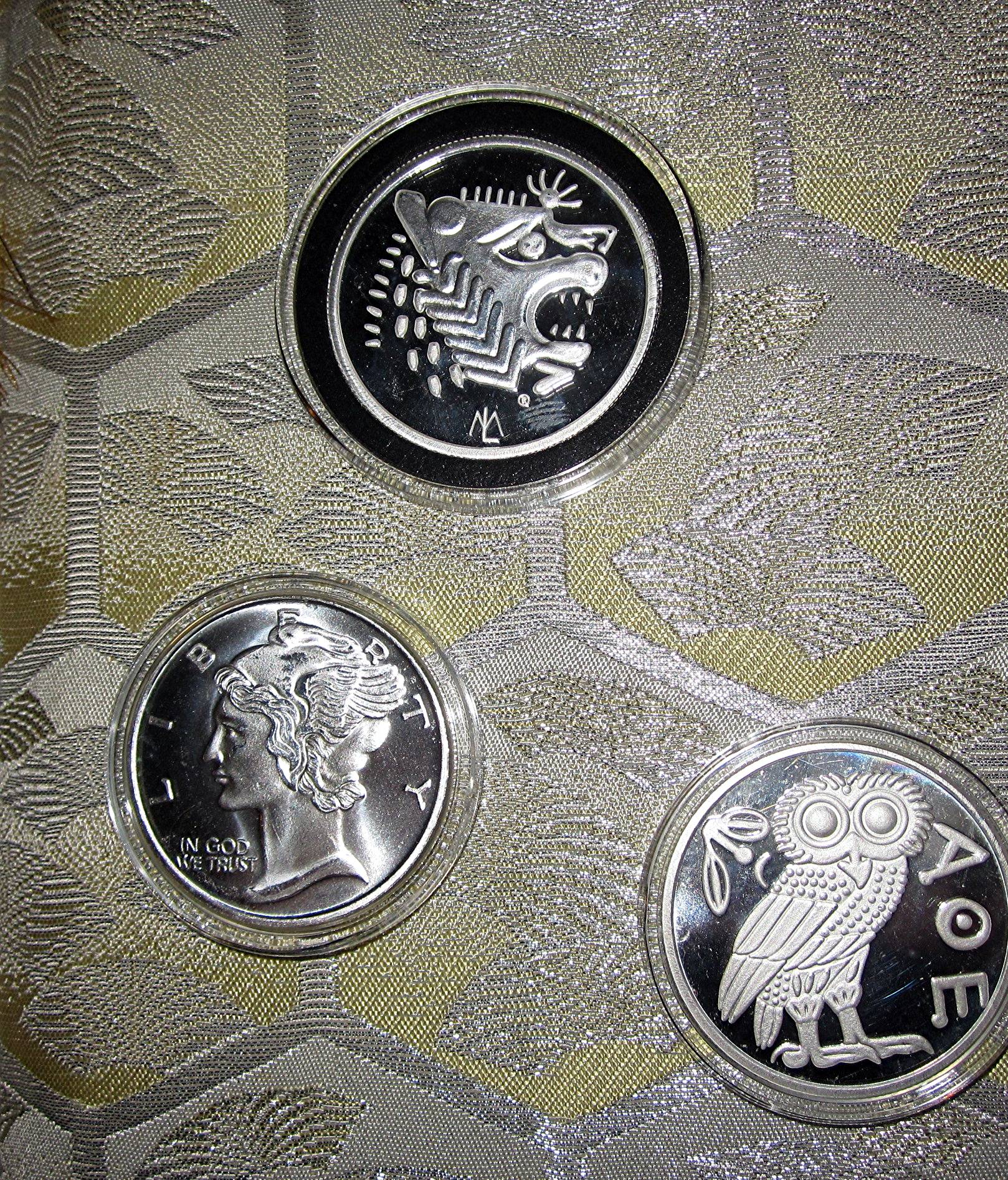 three coins with an owl on top