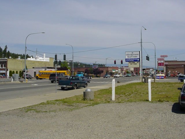 an intersection with traffic near some buildings and a street