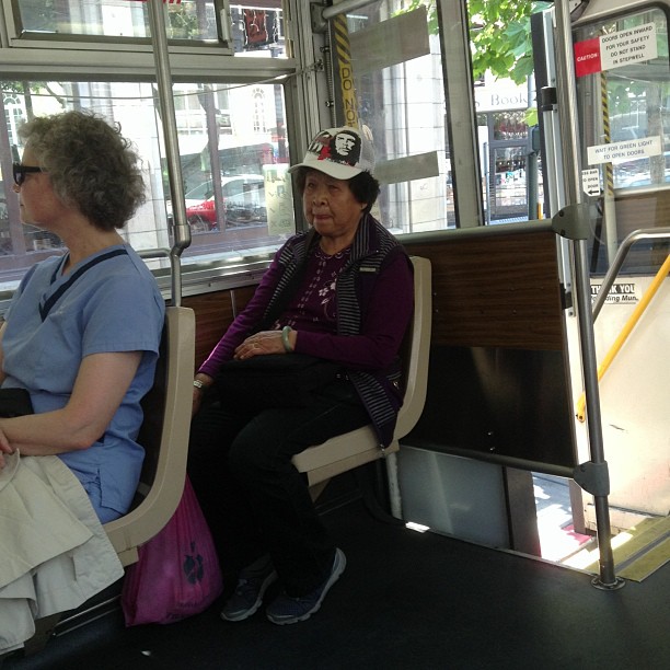two older women sitting on a bus looking out the window