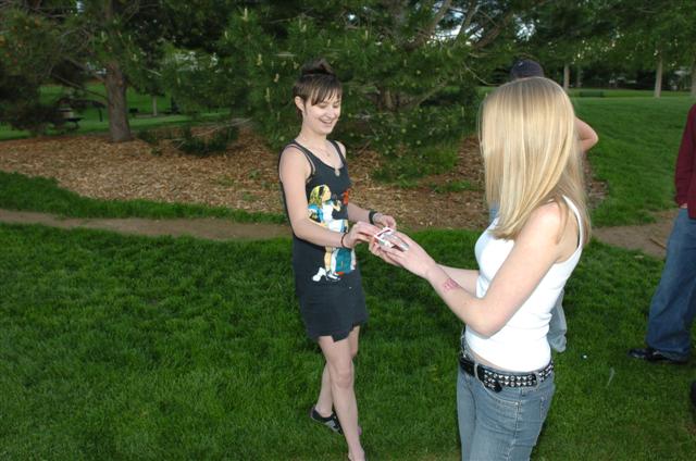 girl handing soing to a man in the grass