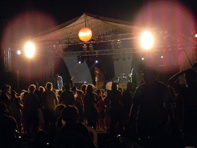 an audience of people under a tent with bright lights