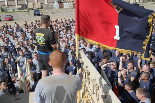 there are many men standing by some large flags