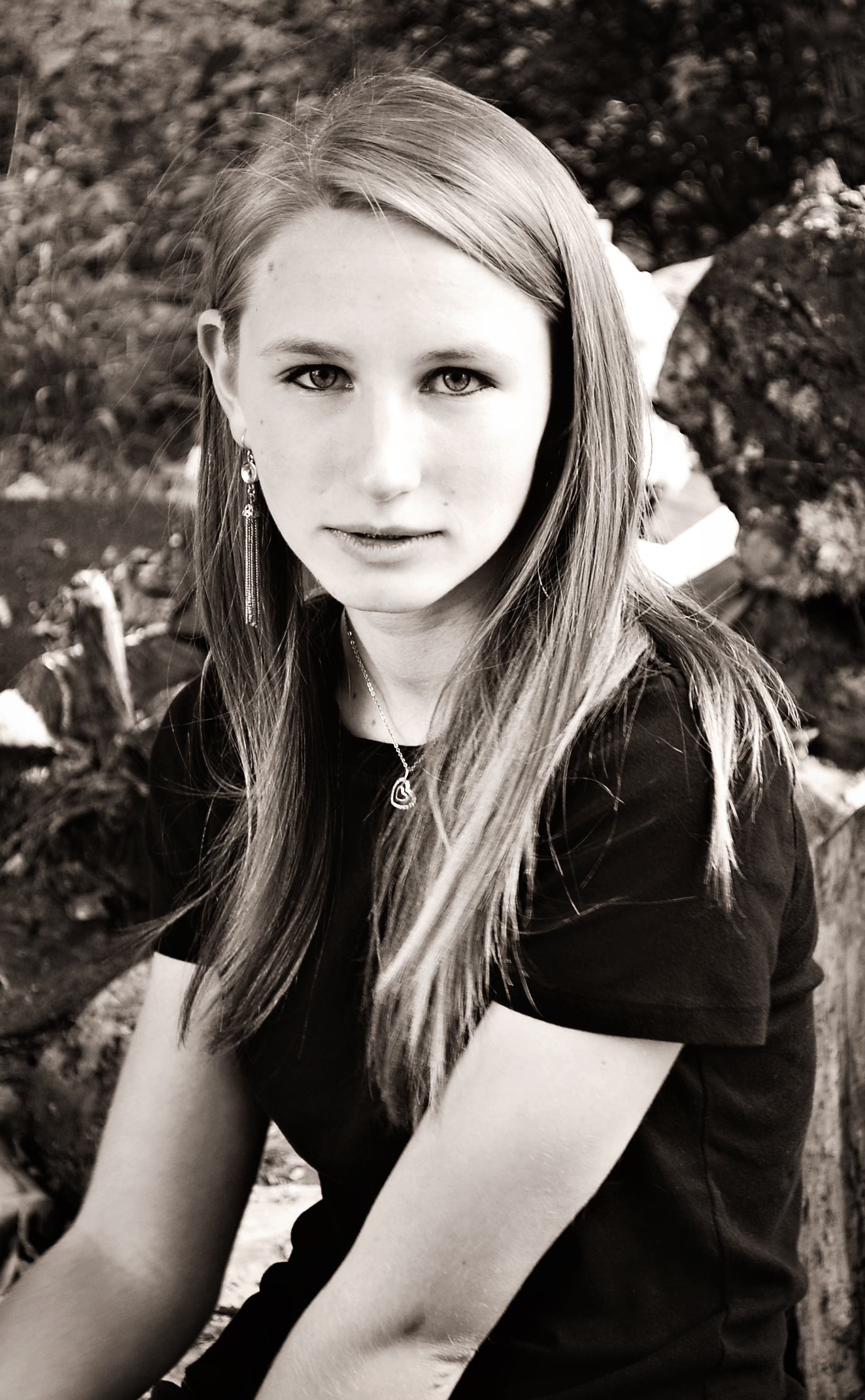 a pretty young lady sitting down in the shade