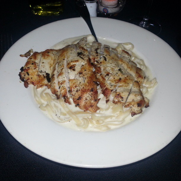 chicken and pasta with alfredo sauce in a white plate