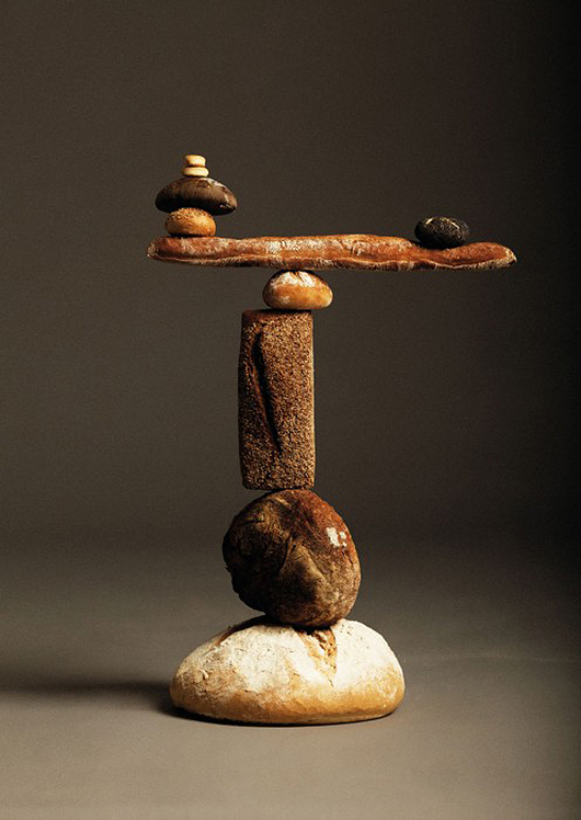 a sculpture of an arm, rock and other rocks