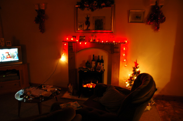a room decorated for christmas with a fireplace and a mantel
