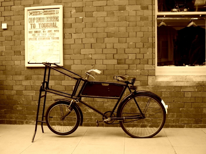 a old bike with two wheels parked near a building