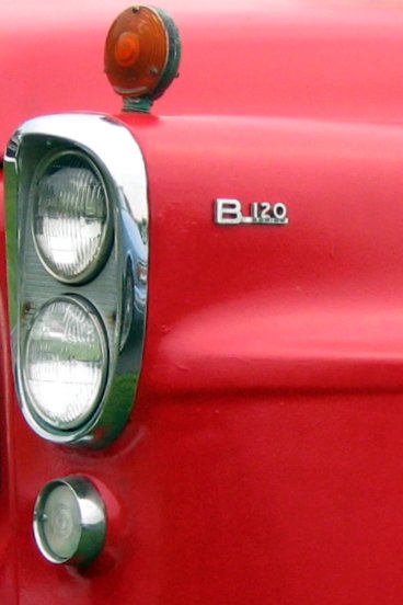 the emblem of an old red car has a red light on it