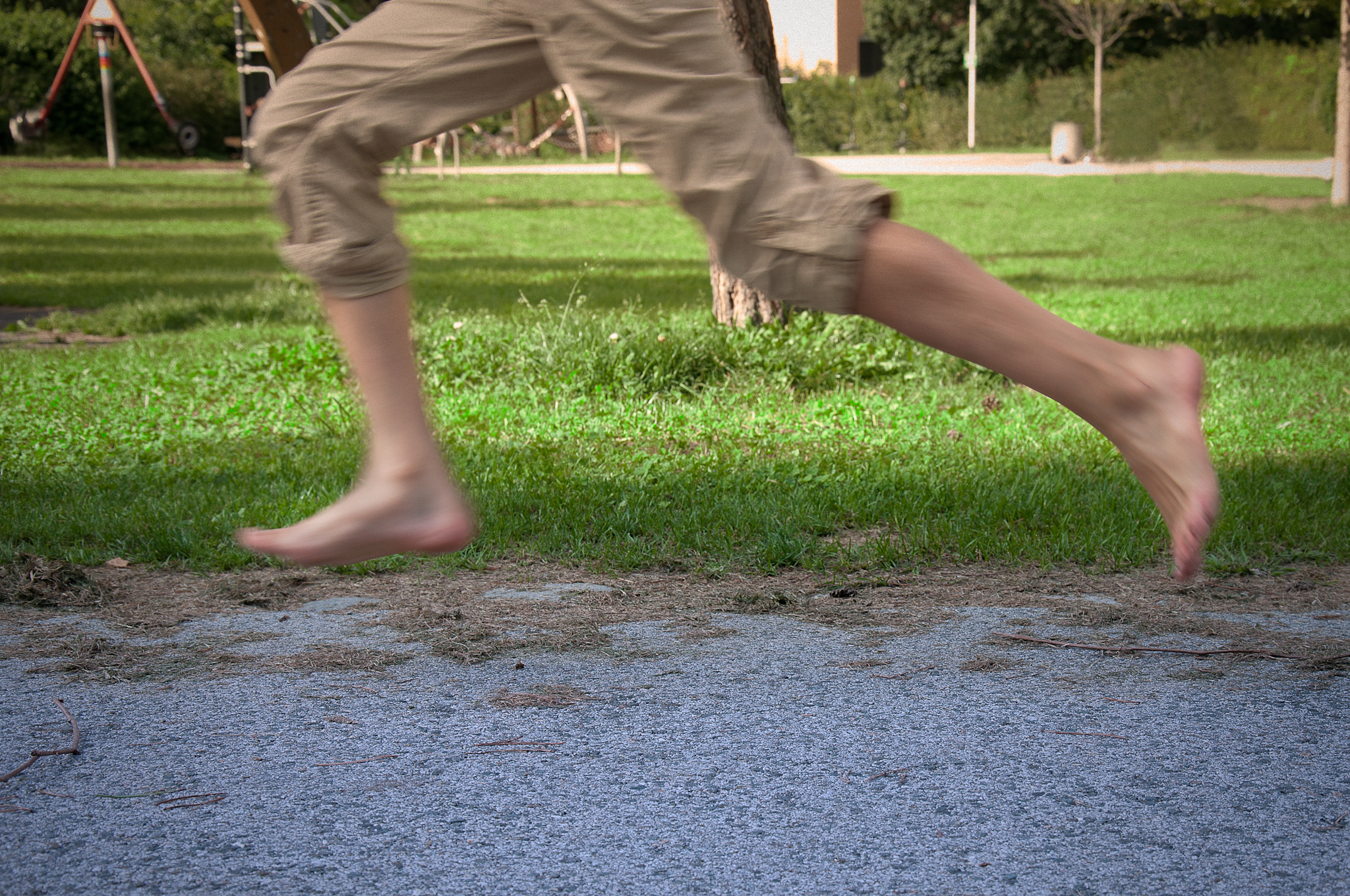 the feet of a man running while playing with a white frisbee
