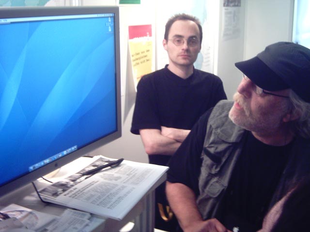 a man is looking at another person on a monitor