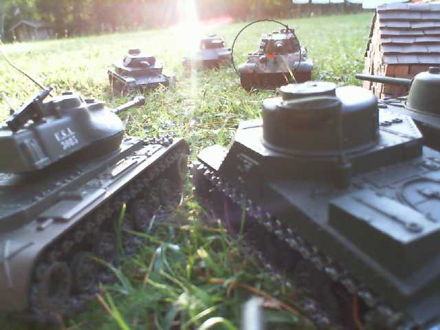 several models of war tanks in the grass