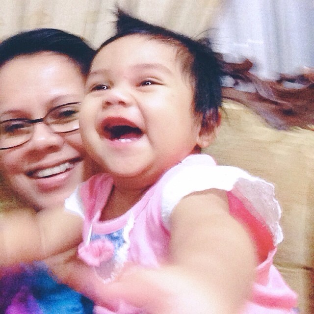 a little girl holding a baby and smiling at the camera