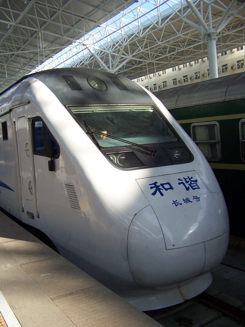 a train sits idle on the tracks next to a loading platform