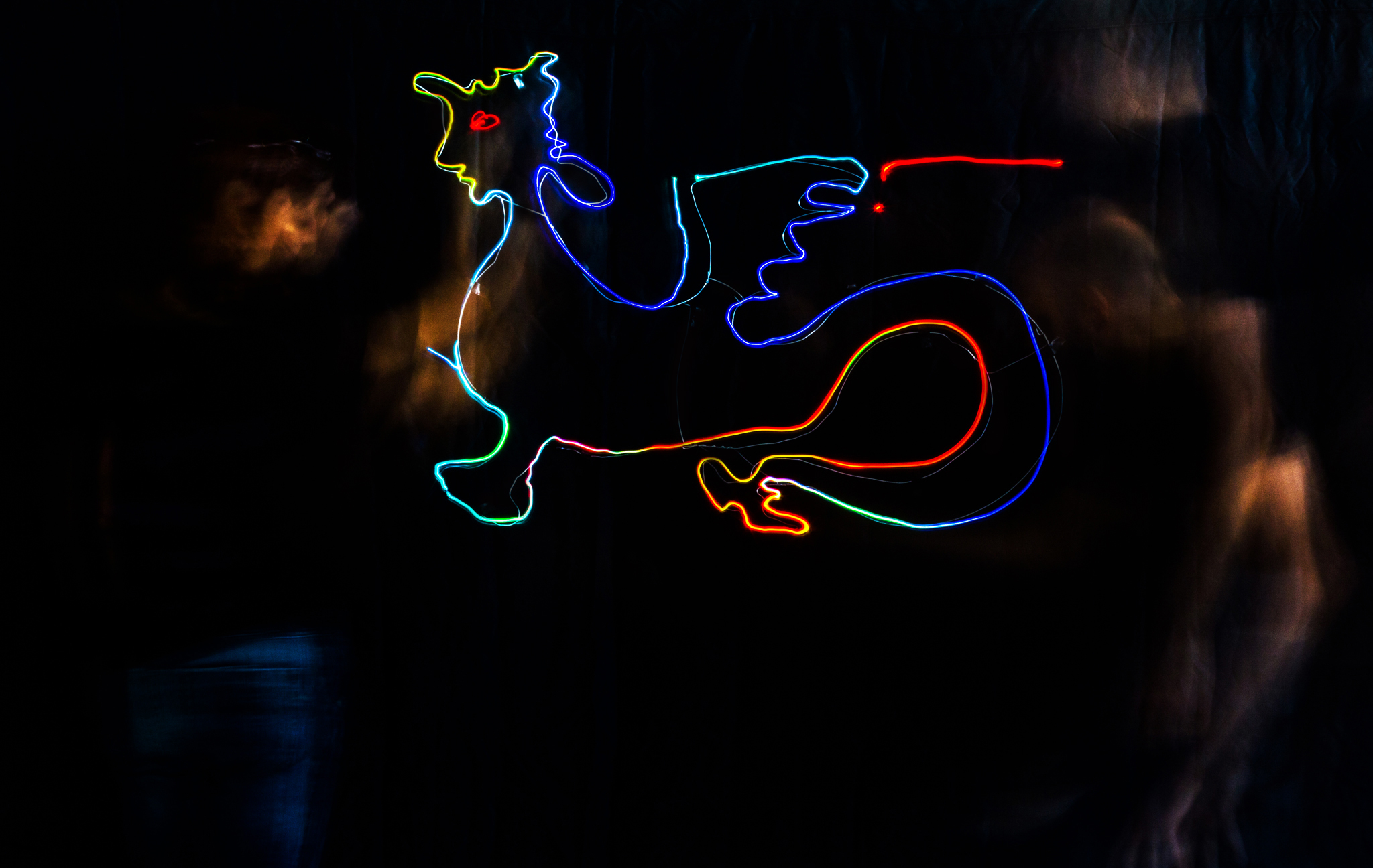 a neon drawing of a flying dragon in a dark background