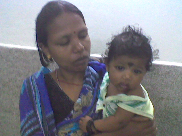 a woman holds a baby while standing