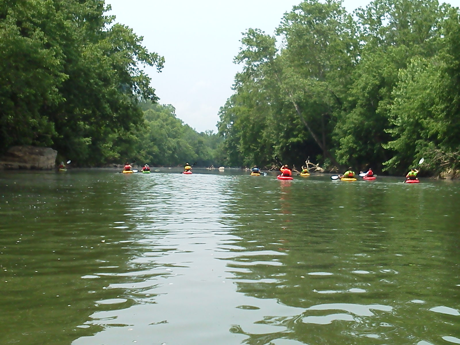 people are rafting down a narrow river in rafts