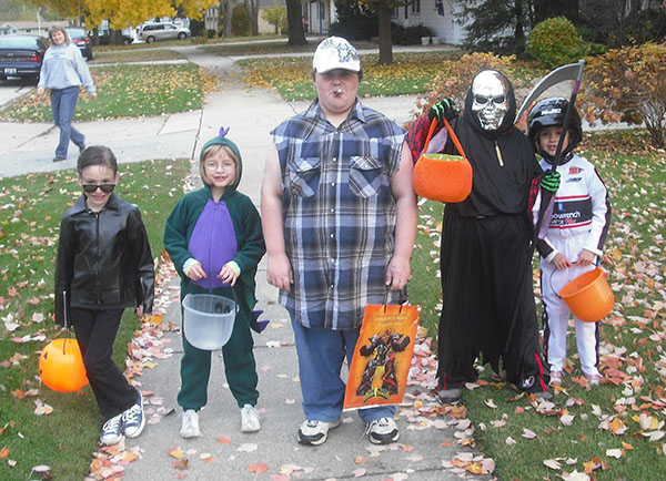 a man, two children, and a woman all wear halloween costumes