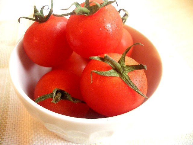 a bowl of tomatoes on a tablecloth